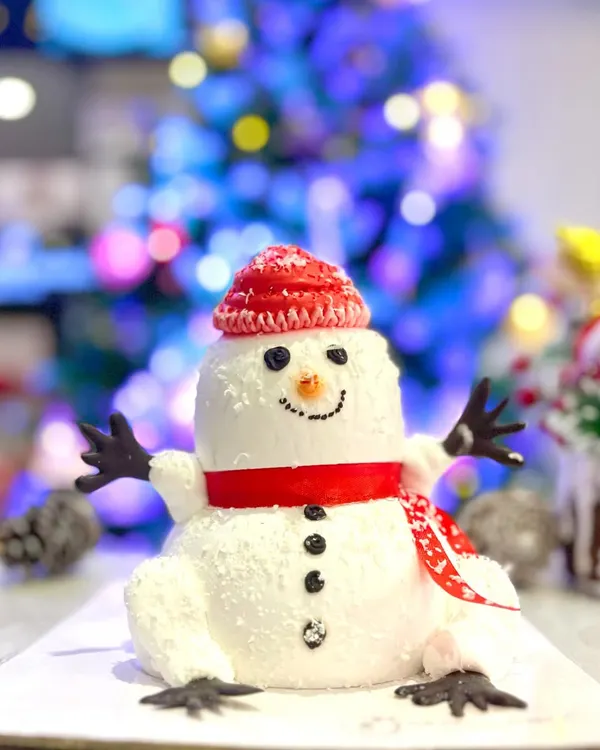 Building a snowman has never been this delicious. This adorable snowman cake, complete with a red knitted hat and scarf, is a fun and festive centerpiece for your Christmas table.