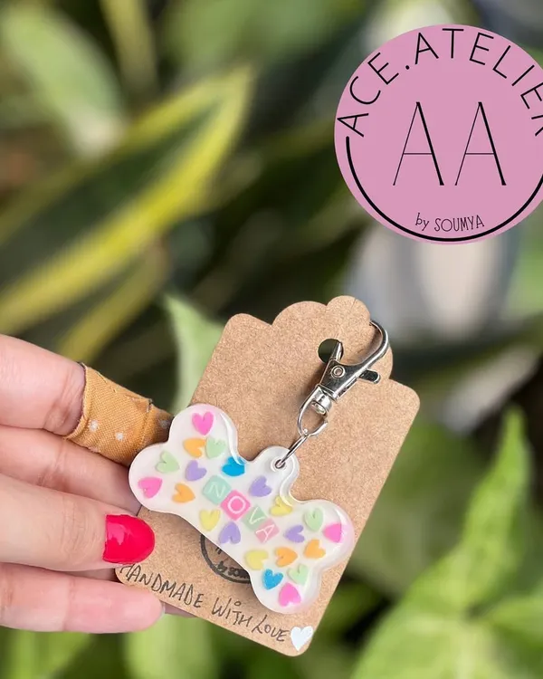 A custom dog tag for a very good boy or girl. This bone-shaped resin tag is filled with colorful heart confetti and can be personalized with your pet's name.