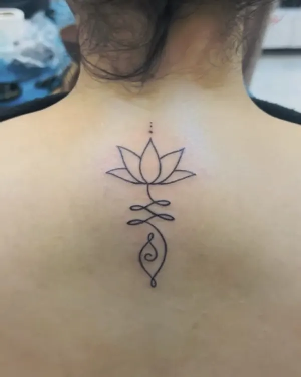 A perfect example of a "one-liner" tattoo. This design combines a lotus and a Unalome symbol in a single, unbroken line on the client's back. It's simple, elegant, and deeply meaningful.