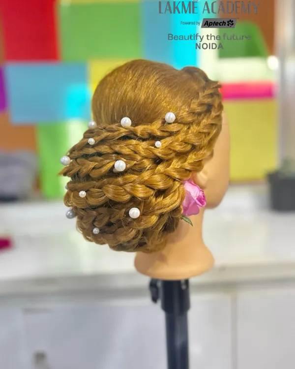 This intricate braided bun, adorned with pearls, is a perfect example of the advanced hairstyling techniques we teach. It's a highly sought-after skill for bridal and formal events.