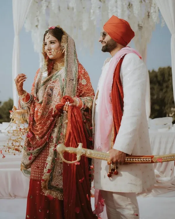 A Sikh couple stands together during their Anand Karaj ceremony. We specialize in capturing the reverence of these moments.
