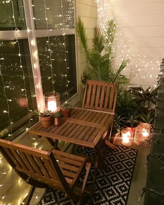 This balcony is all about creating a cozy, romantic atmosphere. I used curtains of fairy lights and candle-lit lanterns to enclose the small bistro set, turning it into a perfect spot for an intimate dinner.