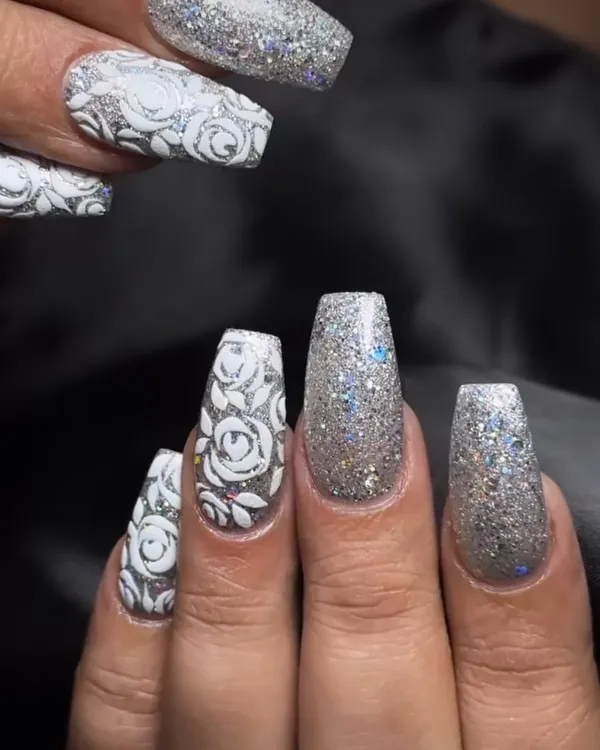 A full-coverage silver glitter nail with a 3D white rose design. This is maximum sparkle and texture.