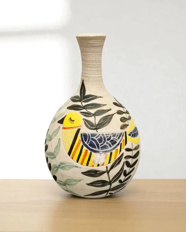 This hand-painted ceramic vase is a lovely piece of art, featuring a colorful bird design. It's more than just a container for flowers; it's a handcrafted item made with care and attention to detail.