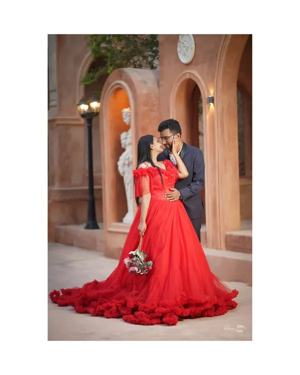 A fairytale moment captured against a backdrop of timeless architecture. This shot embodies the grand romance I love to create, with a stunning red gown that makes a bold, passionate statement.