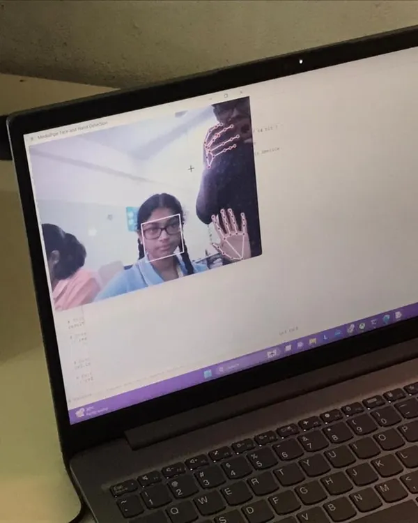 A student's laptop screen shows a Python application using computer vision to detect and track hand movements in real-time.