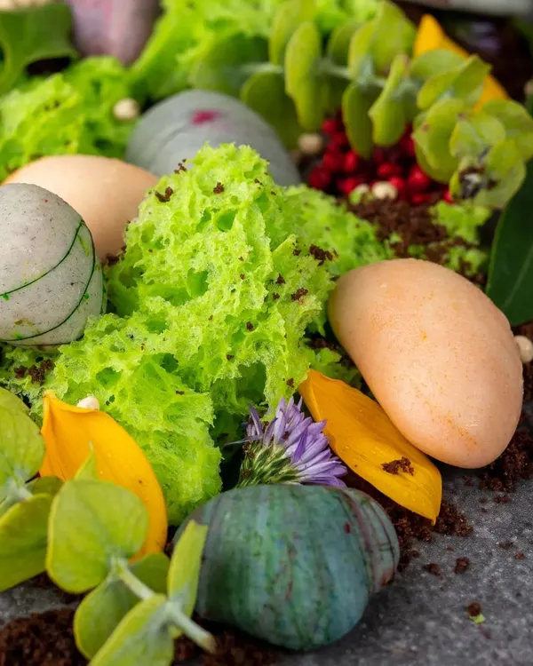 Looks can be deceiving. This dessert, which looks like a collection of pebbles in a garden, is actually an assortment of chocolate and hazelnut petit fours with pistachio sponge and chocolate soil.