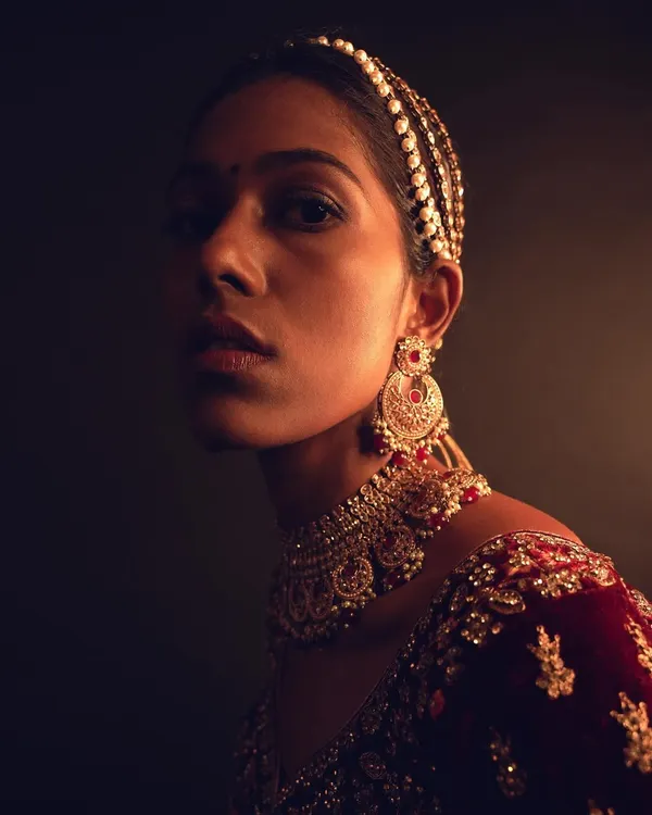 This is a look from a high-fashion ethnic couture shoot. I focused on creating a luminous, glowing effect on the model's beautiful dusky skin, using subtle contouring and highlighting to accentuate her features under dramatic lighting. The makeup was designed to complement the rich velvet lehenga without overpowering it.