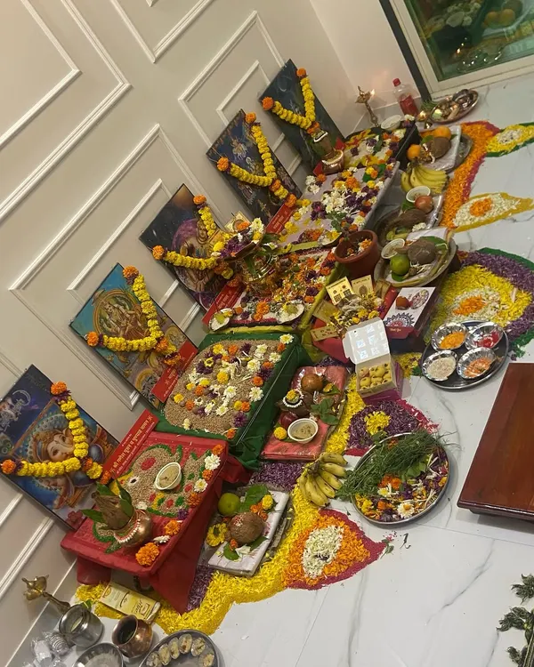 An overhead view of an elaborate Vastu Shanti puja setup. The colorful rangoli, offerings of fruits and flowers, and consecrated items are all part of this powerful ceremony to welcome positive energy.