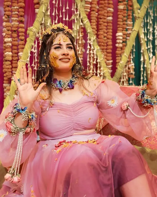 A radiant bride enjoying her Haldi ceremony. This close-up captures her joyful expression as she is covered in turmeric, showcasing the fun and vibrant spirit of the event.