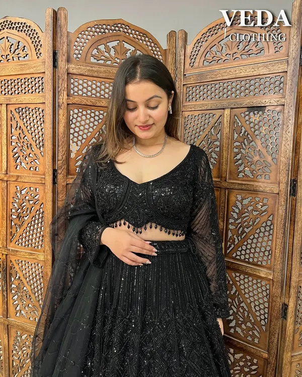 A close-up of the all-black sequin lehenga. The intricate beadwork on the blouse and the sheer sleeves add a touch of modern elegance.