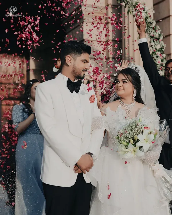 A picture perfect moment. The bride's makeup is soft and romantic, with a gentle glow that looks stunning as she is showered with petals.