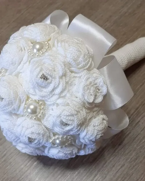 A bridal bouquet that will never wilt. I crafted this beautiful bouquet from dozens of individual white crochet roses, each embellished with pearls and rhinestones and tied with a satin ribbon.