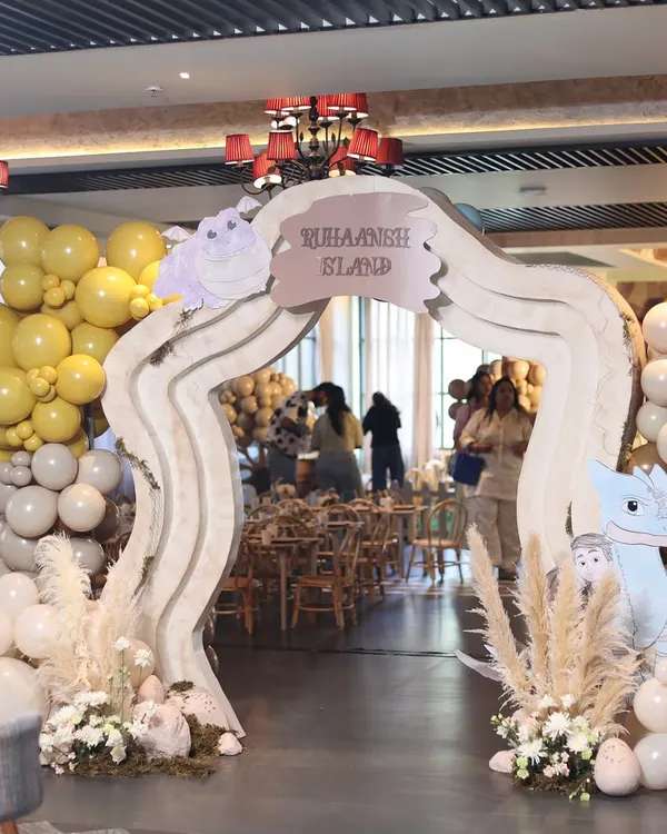 The grand entrance to "Ruhaansh's Dragon Island," where a custom archway, earthy-toned balloons, and pampas grass welcomed guests to a world of adventure.