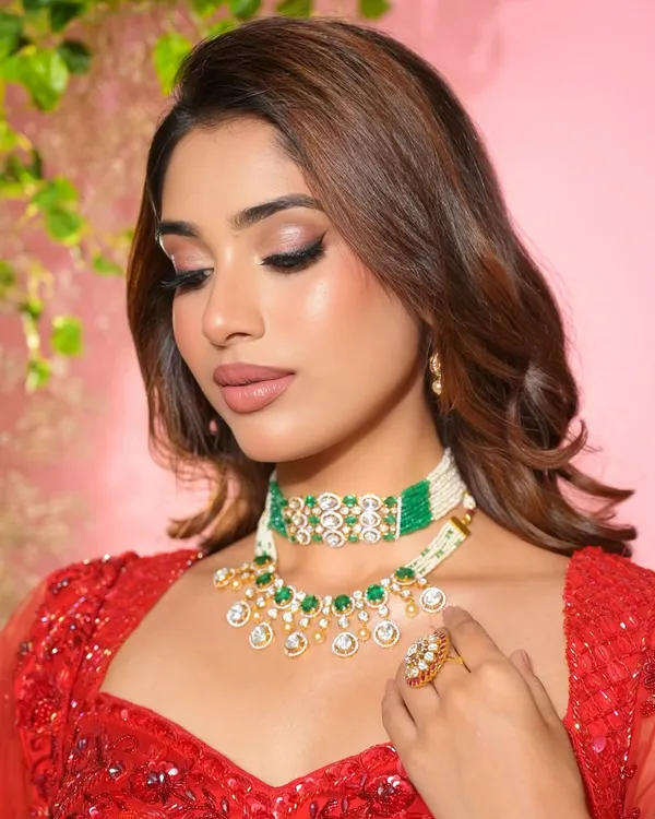 Sister of the groom, but with main character energy. Draped in red and glowing with love, her makeup is glamorous yet elegant, featuring a sharp wing and flawless skin.