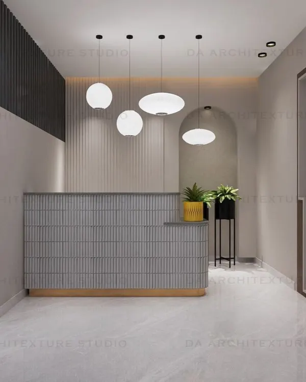 The reception area for a transportation company, featuring a fluted desk, modern pendant lights, and an arched mirror, creating a stylish first impression.