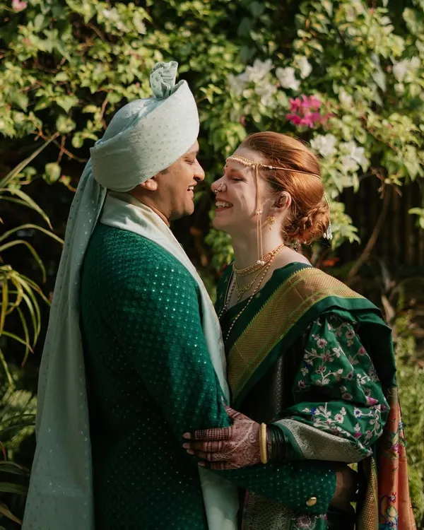 A beautiful, happy moment between the bride and groom during their Marathi wedding ceremony. Rach looks radiant in her traditional Paithani Nauvari saree, and Viraj is handsome in his custom green sherwani.
