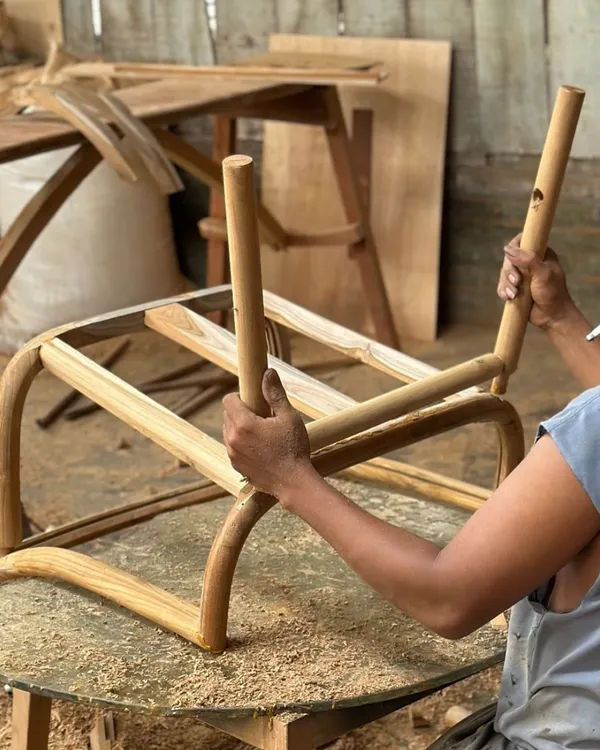 Here, one of my skilled artisans is assembling the frame of a chair. This image captures the hands-on approach and precision that goes into every piece of furniture we create.
