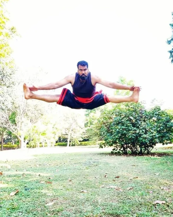 Master Moideen Rafi demonstrating a flying split, a testament to the incredible martial arts flexibility and power developed through years of dedicated Kalaripayattu practice.