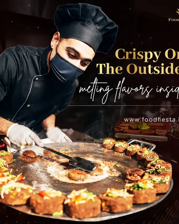 A chef preparing crispy Aloo Tikkis on a large tawa at a live station. Each tikki is fried to golden perfection, ready to be topped with chutneys and yogurt for that classic street food experience.