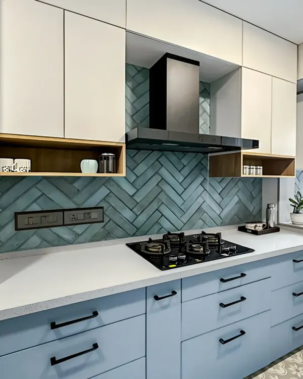 This L-shaped kitchen features a beautiful herringbone tile backsplash. The combination of powder blue and white cabinets with matte black hardware creates a fresh, contemporary look.