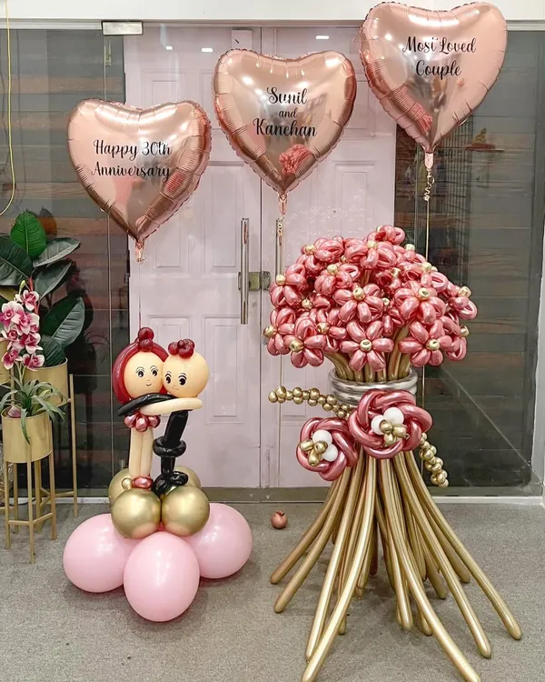 A beautiful and romantic arrangement for a 30th anniversary. This set includes a large balloon flower bouquet, a sculpted couple figurine, and personalized rose gold heart balloons to celebrate a "Most Loved Couple."