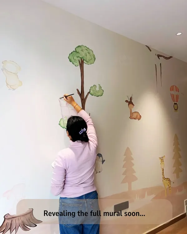 A full view of the nursery mural in progress. You can see the gentle landscape and the placement of the various woodland animals, all coming together to create a whimsical world.