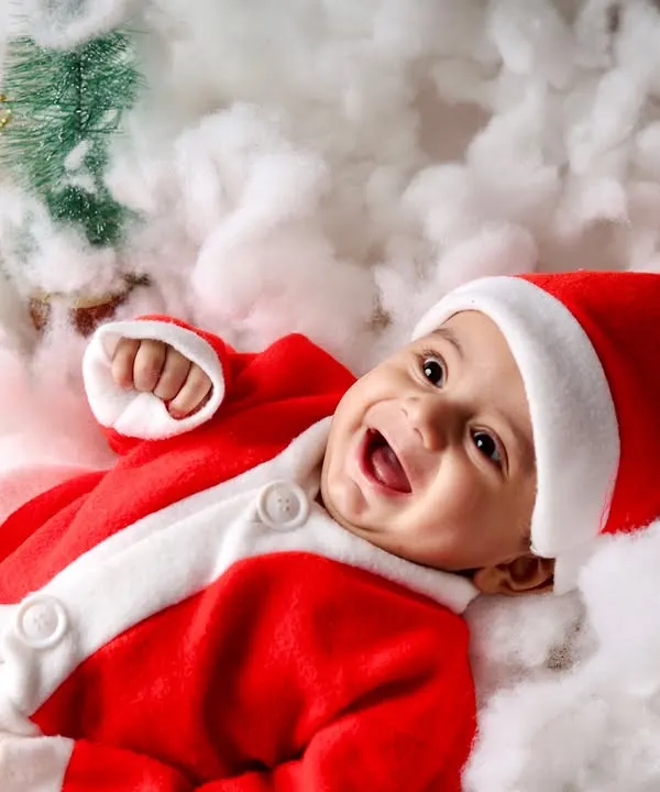 The happiest little Santa. This baby's joyful laugh is the highlight of this Christmas mini-session, surrounded by fluffy white "snow."