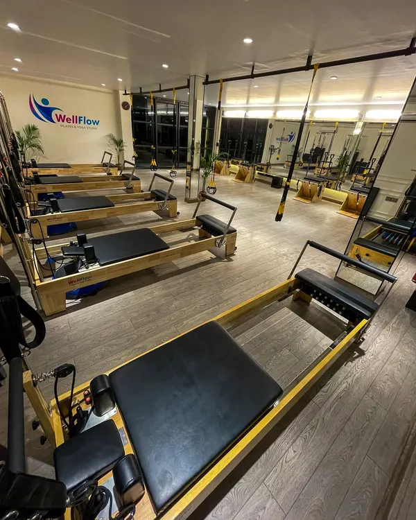 An evening view of our studio, ready for the next session. The combination of reformers, TRX stations, and open space allows for a wide variety of functional workouts.