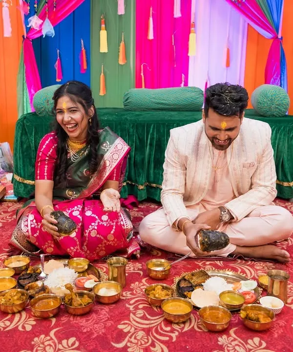 A candid moment of pure laughter during a pre-wedding ritual. The vibrant colors of the decor mirror the joy shared between the couple.
