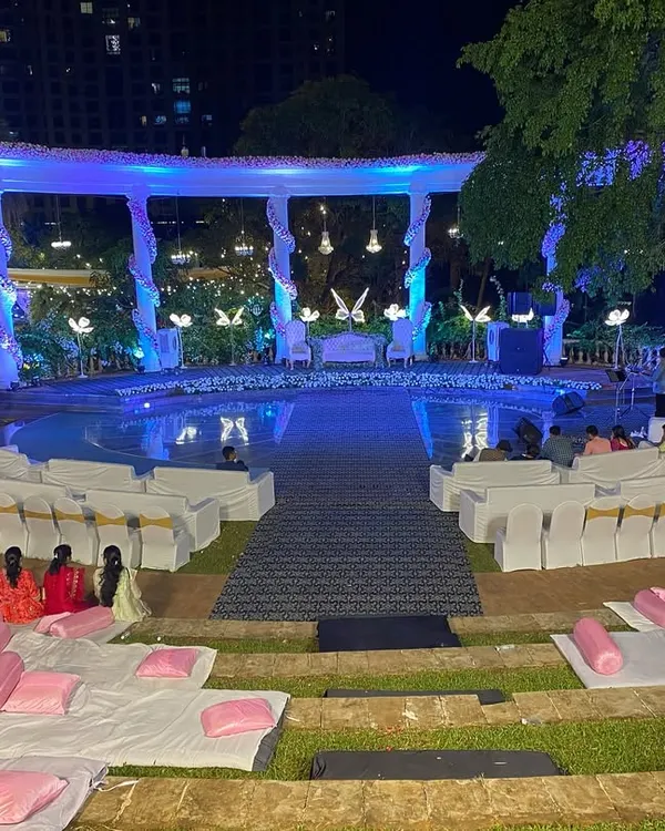 A wide view of the poolside reception stage at Raheja Exotica. We arranged both formal chair seating and casual floor seating with cushions, ensuring all guests had a great view of the main event.