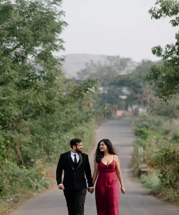 A walk down a quiet country road, surrounded by lush greenery. This wide shot establishes a sense of journey and togetherness, perfect for a destination pre-wedding story.