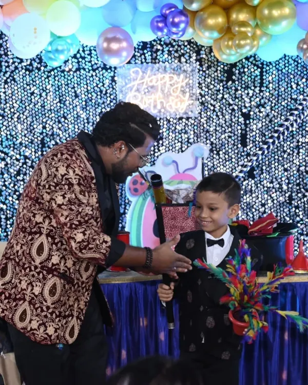 Making the birthday boy the star of the show. Here, he's helping me with a colorful flower wand trick, creating a magical moment just for him.