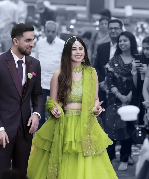 The couple makes their grand entrance at the Sangeet. The selective color effect puts the focus squarely on them, highlighting their joy amidst the crowd.