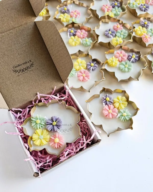 A beautiful Urli candle with pastel daisy flowers being placed in a custom box. This order was for Harini's brand, a perfect example of my white-label work.