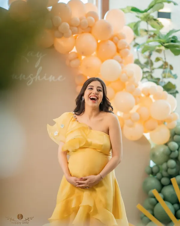 The pure joy and laughter of a mom-to-be at her baby shower. This candid shot captures her radiant happiness, surrounded by cheerful yellow and green decor.
