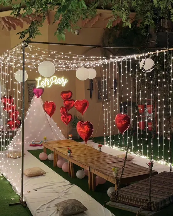 This is one of my favorite setups for a truly intimate and memorable evening. I create a magical atmosphere with a canopy of fairy lights, a cozy teepee tent, and comfortable low seating, perfect for a unique date night or a surprise proposal in your own garden or terrace.