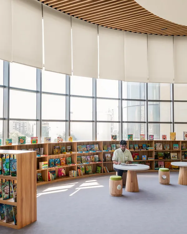 The library at Vedanya School, Gurugram, is a space for the mind to roam free. The curved, expansive windows flood the room with natural light, while the child-friendly furniture and accessible bookshelves create a welcoming atmosphere for young readers.
