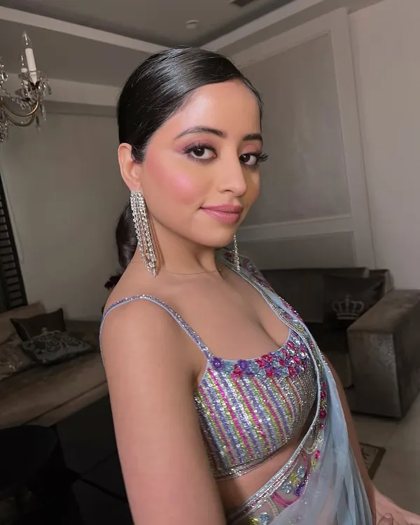 A close-up of a client with a pop of pink on the eyes and a sleek ponytail. This look is crafted with intention to highlight natural beauty.