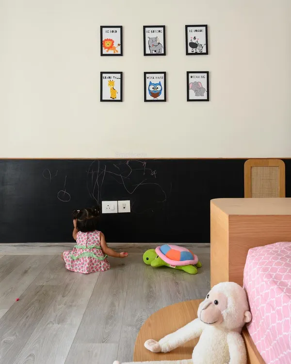 The daughter's bedroom in 'Cover me in Sunshine' is a blush haven with a chalkboard wall for creativity. The platform bed and all furniture are designed to be within a toddler's reach, ensuring the space is both beautiful and accessible.