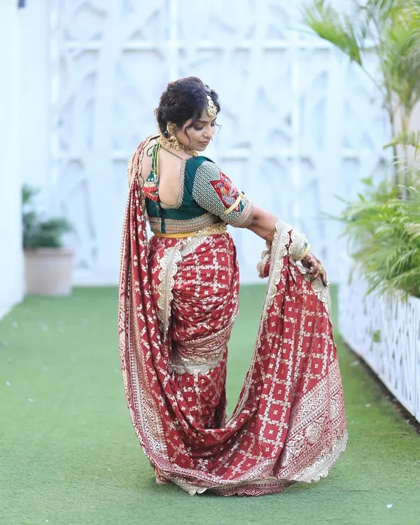 A beautiful customer looking radiant in a red bandhani-style Nauvari for her wedding function.