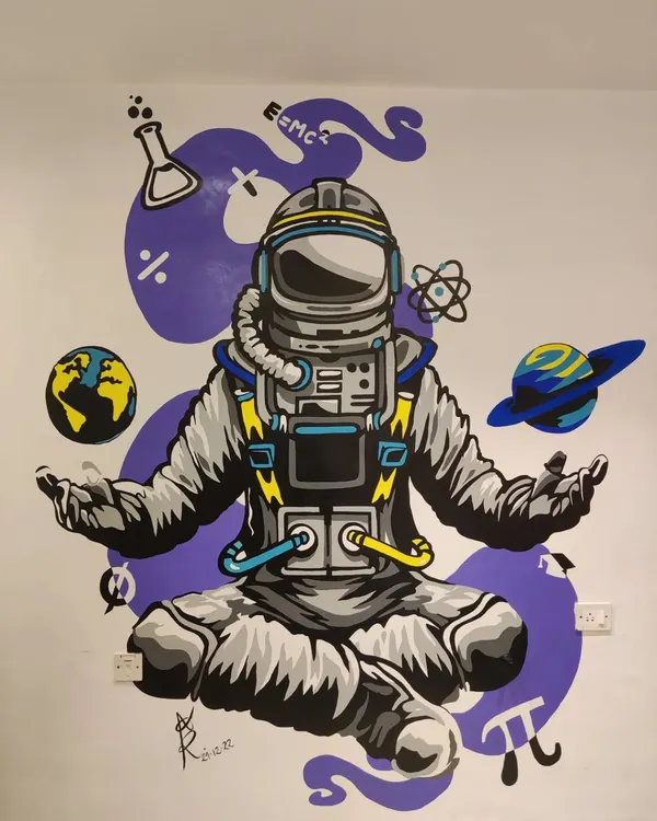 The completed astronaut mural, designed to make learning fun at a Mumbai teaching institute. This graphic wall art features a meditating astronaut surrounded by symbols of science and space, creating a cool and engaging environment.