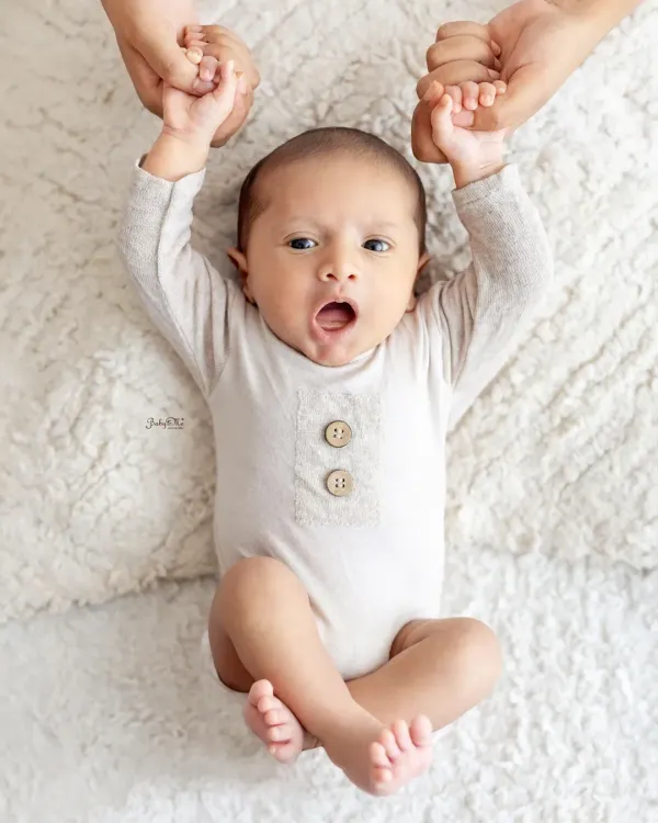 Look at that adorable yawn. I love capturing these spontaneous, cute expressions during a newborn session. This little one is resting on a soft, fluffy rug.