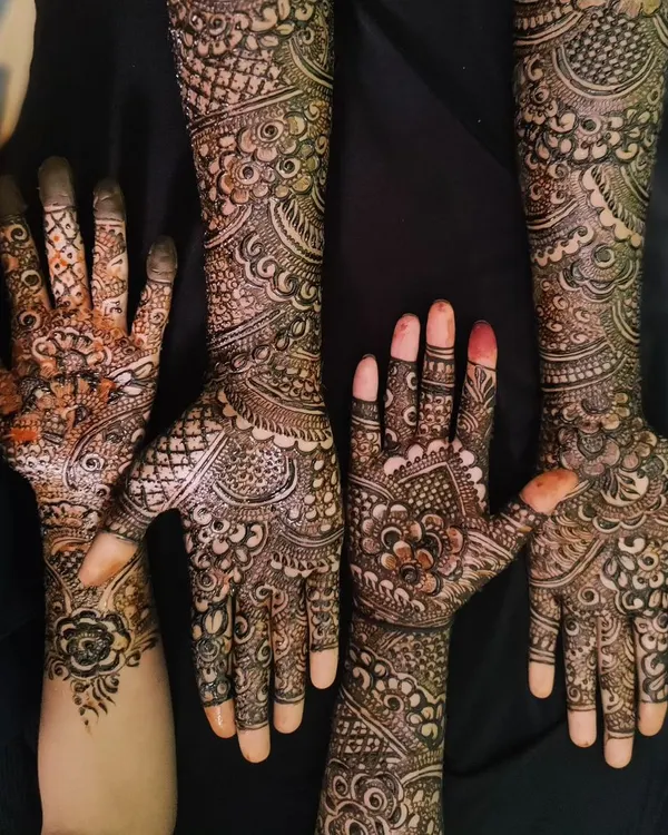 A fun shot of a group of friends showing off their matching and complementary henna designs. It's always more fun to get mehndi done together.