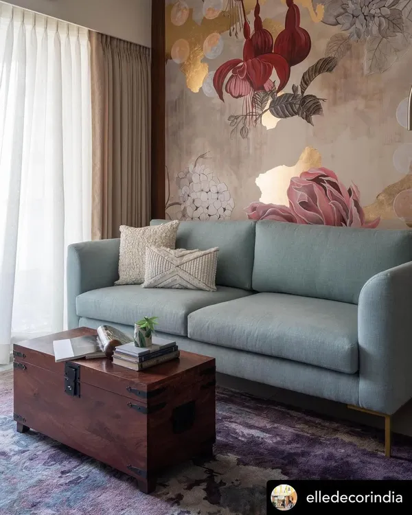 The 'Native Grace' mural, featured in Elle Decor, serves as the heart of this living room. The artwork combines fuchsia, peonies, and hydrangeas with touches of gold leaf, creating a piece that is both elegant and expressive.