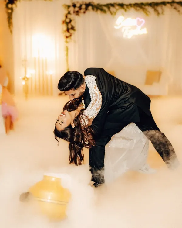 A dramatic dip on the dance floor, surrounded by theatrical smoke. This shot captures the peak of the couple's first dance performance, full of passion and flair.
