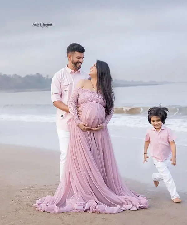 A beautiful family of three, soon to be four, enjoying a quiet moment on the beach. We love capturing these maternity announcement photos with the whole family.