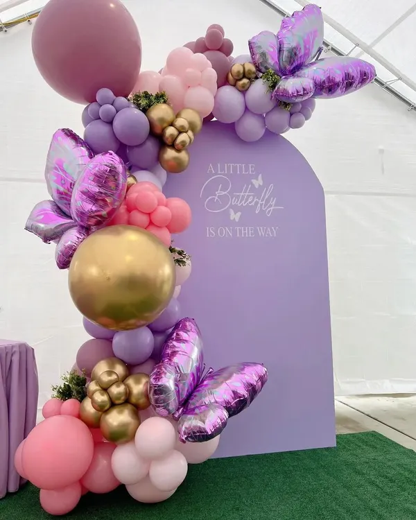 Our butterfly theme is perfect for a modern and graceful baby shower. The custom-arched lavender backdrop provides a beautiful canvas for the elaborate balloon garland and large foil butterflies, creating a truly enchanting scene.