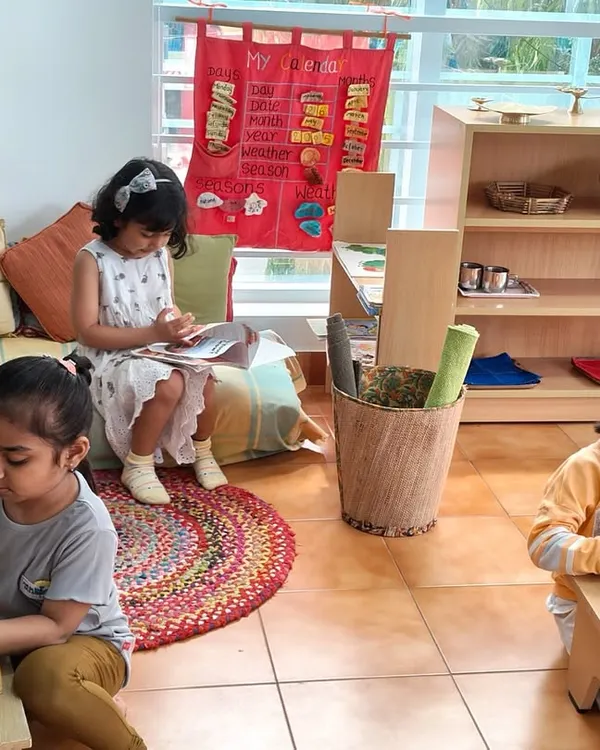 This is the essence of our Montessori environment. Here you see three children, each deeply engaged in their chosen activity, learning and exploring at their own individual pace in a calm, shared space.