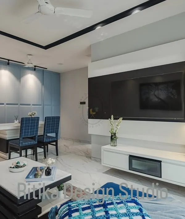 This is a great example of an open-plan living and dining area. I used a consistent color palette of blues, greys, and whites to connect the two zones, while the paneling on the dining room wall adds texture and definition. The floating TV console and backlit shelves provide storage without adding bulk.